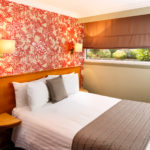 Compact double room at Mercure Chester Abbots Well Hotel, red floral wallpaper, view of garden