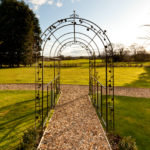 Exterior shot of the gardens at Mercure Chester Abbots Well Hotel, metal archway