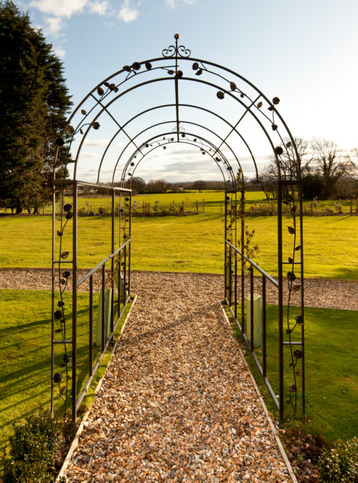 Exterior shot of the gardens at Mercure Chester Abbots Well Hotel, metal archway