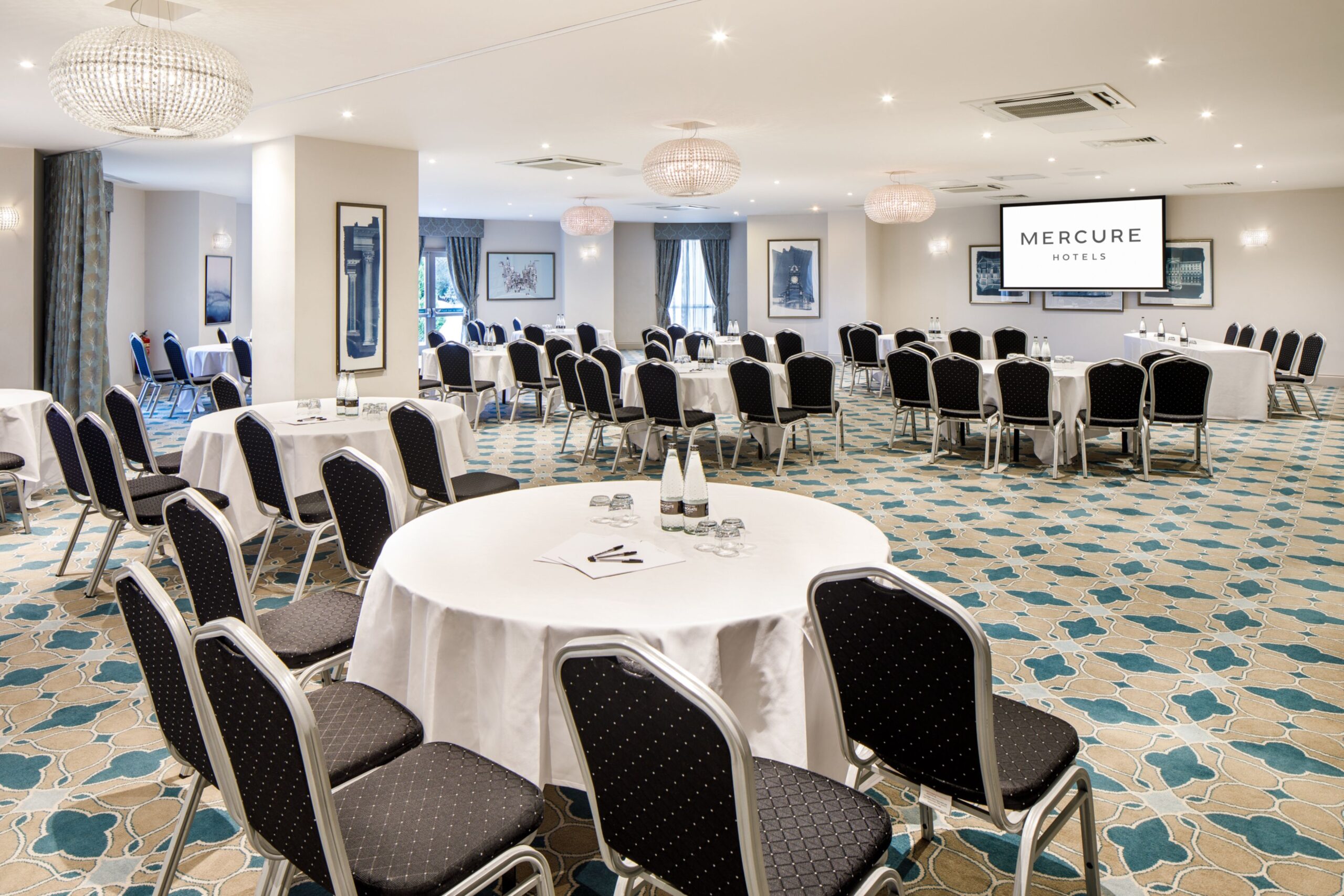 Angled view of The Lakeside Suite at mercure gloucester bowden hall hotel ready for a conference and presentation on the large video screen